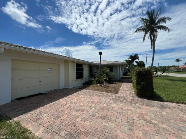 Ranch-style home with an attached garage, stucco siding, decorative driveway, and a tile roof