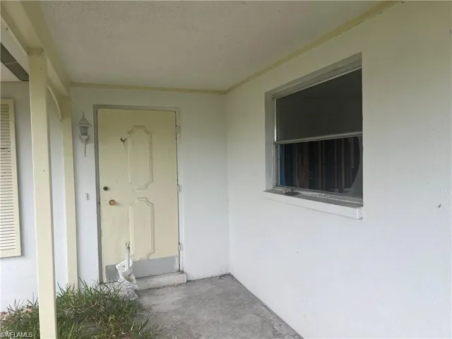 Doorway to property featuring stucco siding