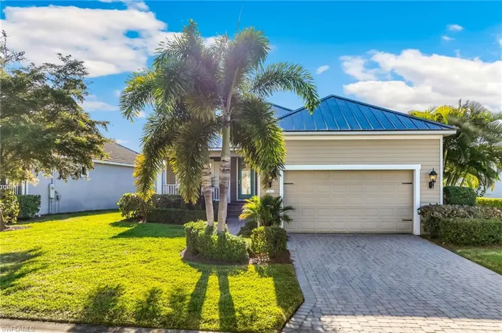 View of front of home with decorative driveway, a front lawn, a two-car attached  garage.