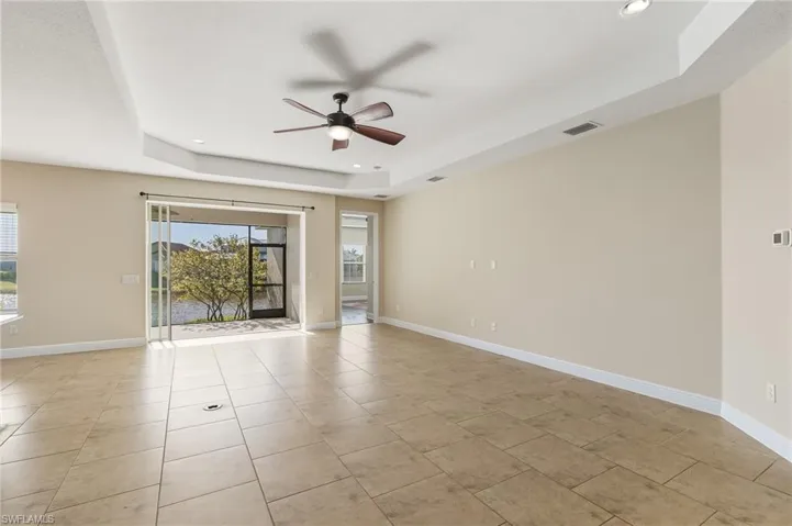 View of the living room looking out onto the screened lanai/porch with the entry to the master bedroom on the right.