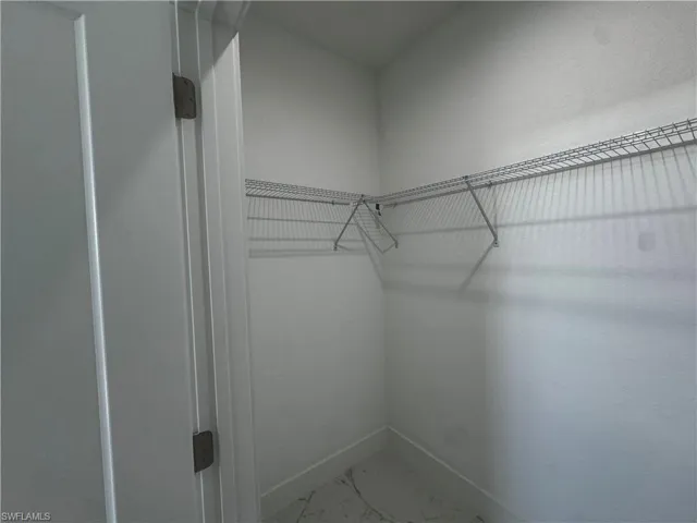 Spacious closet featuring marble finish floor