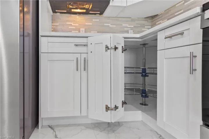 Bathroom featuring marble finish flooring and backsplash