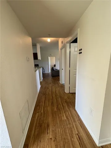 Hall featuring dark wood-type flooring