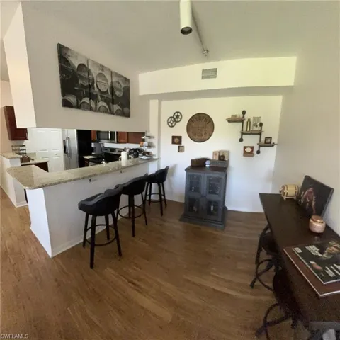 Office featuring dark hardwood / wood-style flooring and rail lighting
