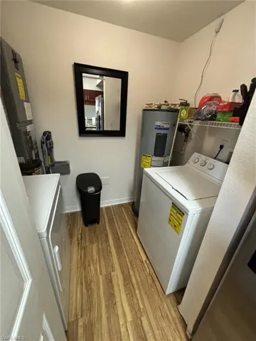 Laundry area featuring water heater, washer / clothes dryer, and light hardwood / wood-style flooring