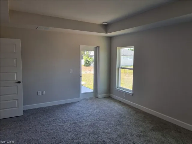 Empty room featuring visible vents, baseboards, and carpet floors