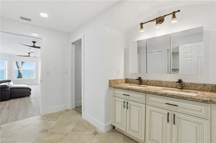 Ensuite bathroom featuring double vanity and light wood-style floors - Virtually Edited Image