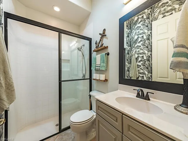 Bathroom with walk in shower, vanity, and toilet