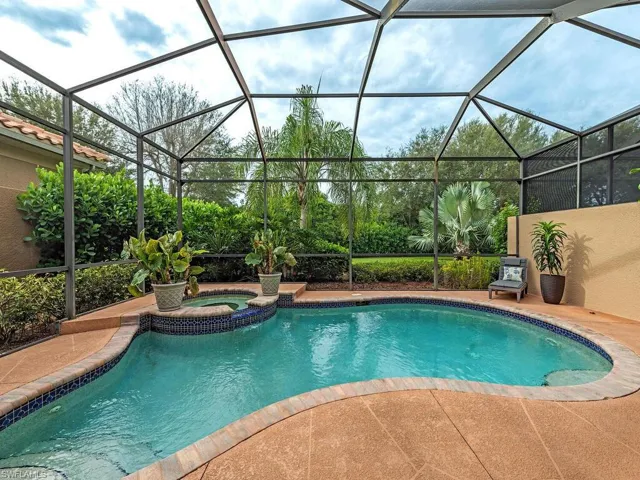View of swimming pool with a lanai, a patio, and an in ground hot tub