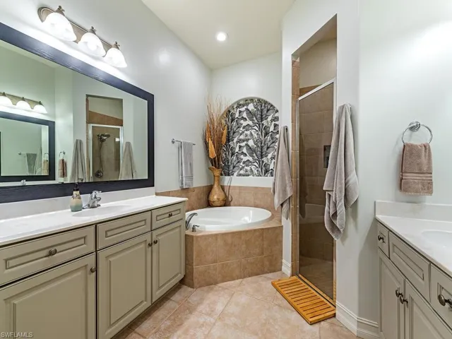 Bathroom featuring tile patterned floors, independent shower and bath, and vanity