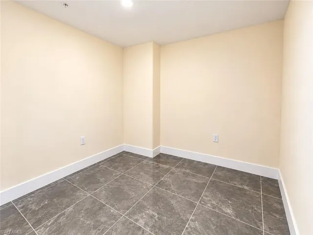 Neutral-toned walls paired with large-format, stone-finish tile flooring and recessed ceiling lighting