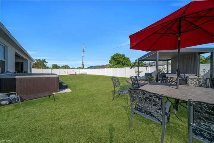 Fenced backyard with a patio and a hot tub