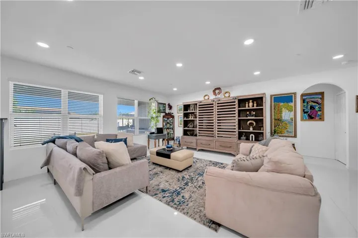 Living area featuring recessed lighting, arched walkways, and tile patterned flooring
