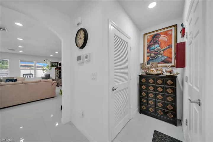 Hallway with recessed lighting, arched walkways, and light tile patterned floors