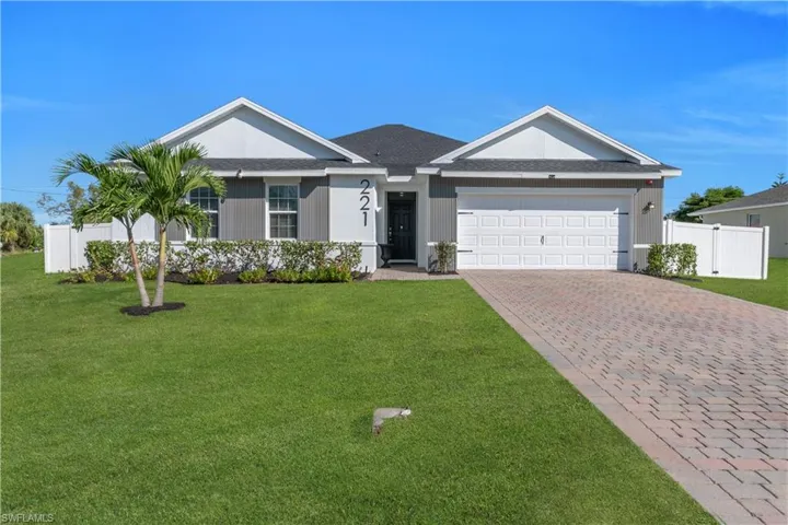 Ranch-style house featuring decorative driveway, an attached garage, and roof with shingles