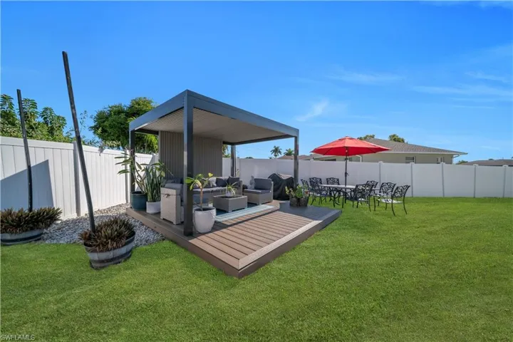 Fenced backyard with an outdoor living space and a wooden deck
