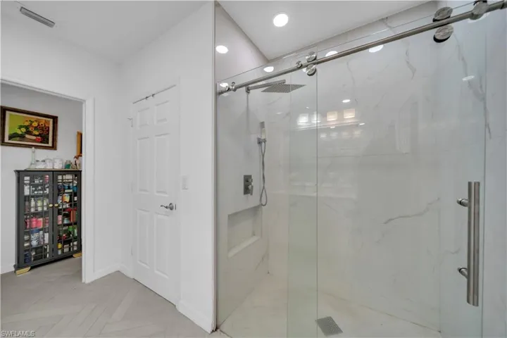 Full bath featuring a marble finish shower and recessed lighting