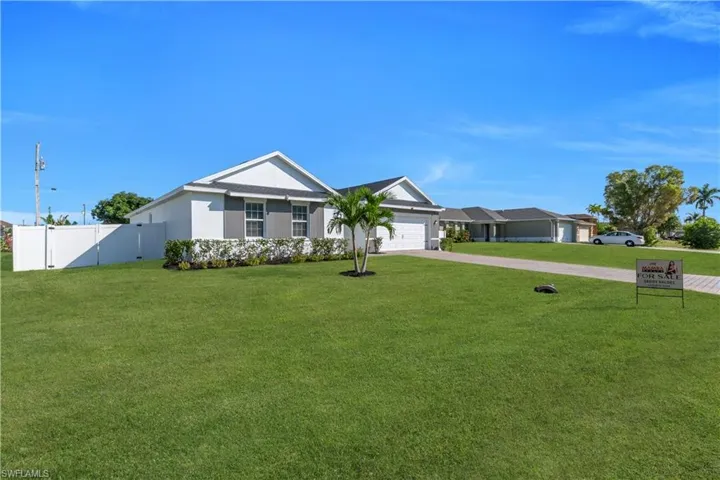 Single story home featuring driveway, stucco siding, and an attached garage