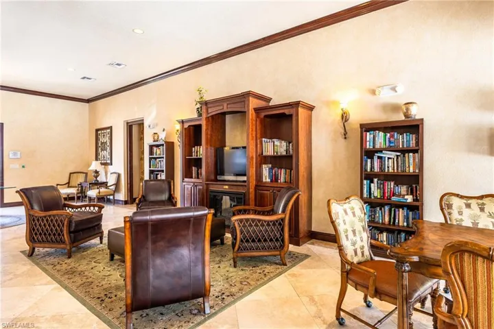 Living room featuring crown molding and a glass covered fireplace