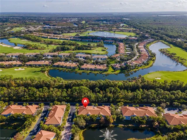 Aerial view of property and surrounding area featuring a large body of water, a golf club, and nearby suburban area