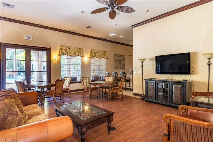 Living room featuring crown molding, ceiling fan, wood finished floors, and a textured wall