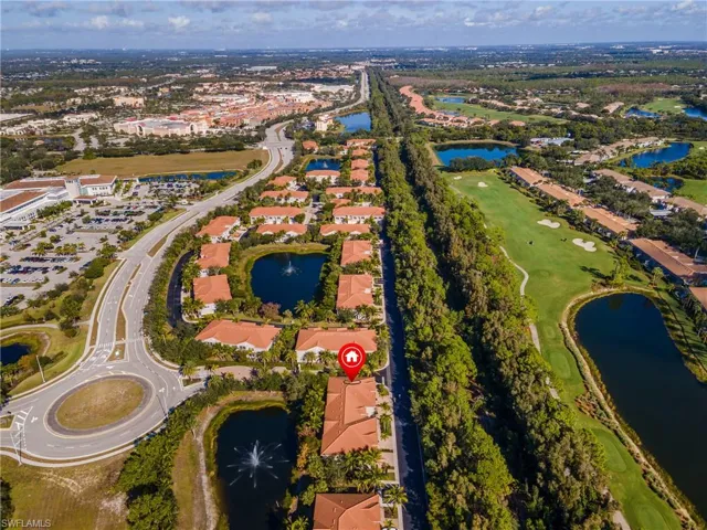 Aerial view of property's location featuring a large body of water, a golf course, and nearby suburban area