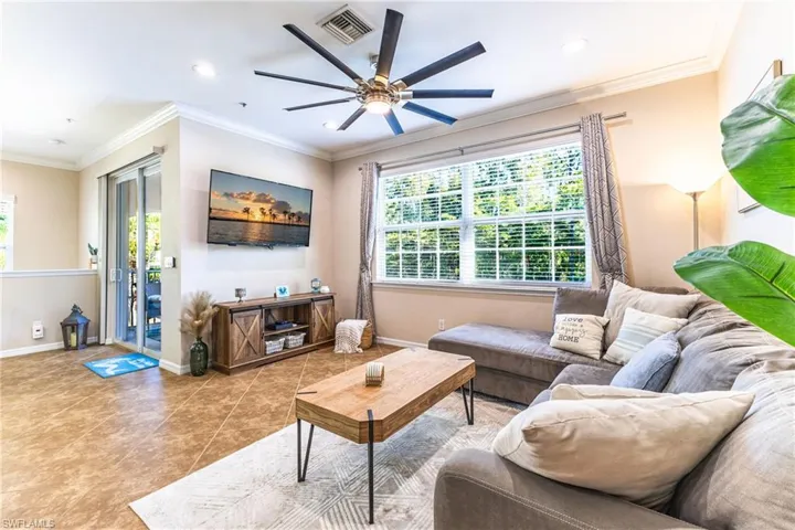 Living room with crown molding, a ceiling fan, tile patterned flooring, and recessed lighting