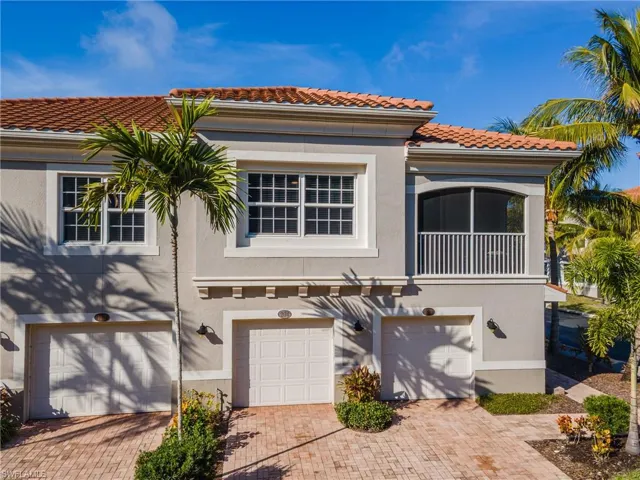 Mediterranean / spanish home featuring stucco siding, a garage, a tile roof, and decorative driveway