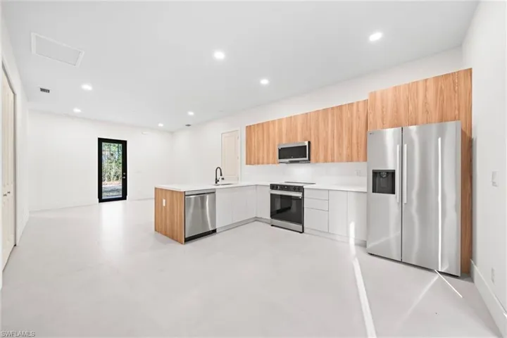 Kitchen with stainless steel appliances, modern cabinets, a peninsula, and recessed lighting