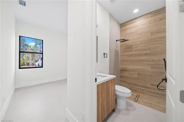 Bathroom featuring vanity, tiled shower, and recessed lighting