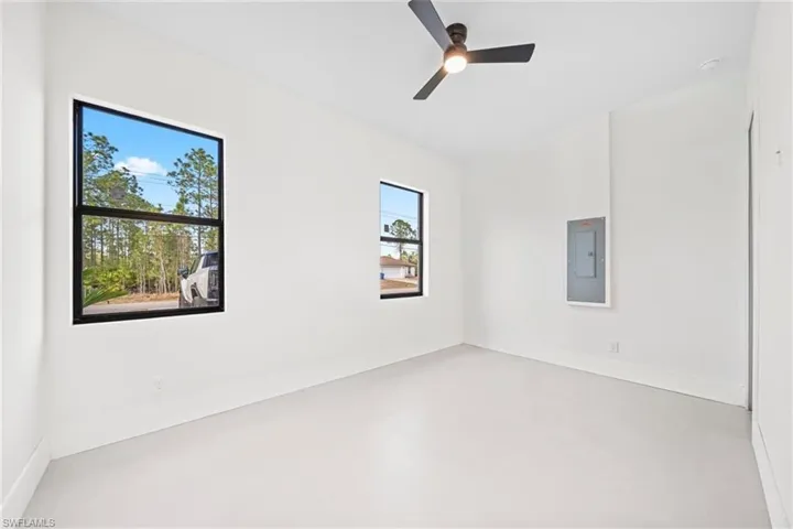 Unfurnished room with electric panel and ceiling fan