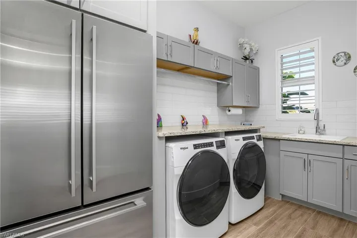 Doing laundry won't be a chore in this amazing laundry room! You'll love the extra storage space, utility sink and additional full-size refrigerator/freezer!