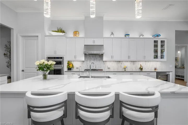 Kitchen features custom backsplash, designer lighting, cabinetry with pull out drawers, and upgraded stainless steel appliances.
