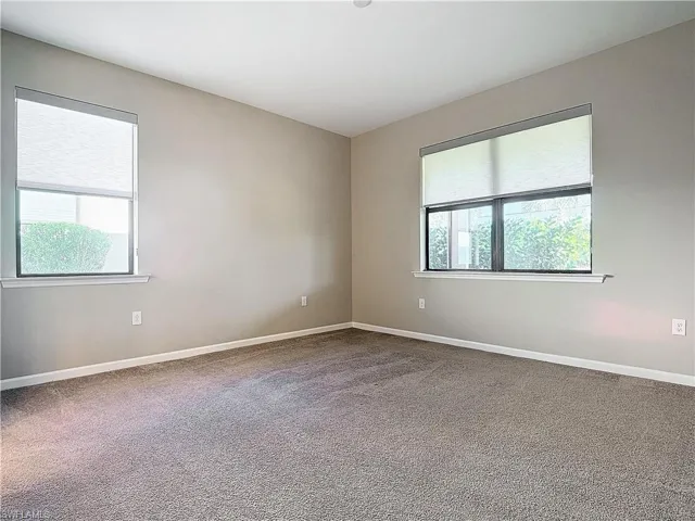 Carpeted spare room featuring baseboards