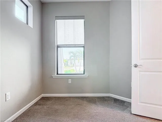 Carpeted empty room featuring baseboards