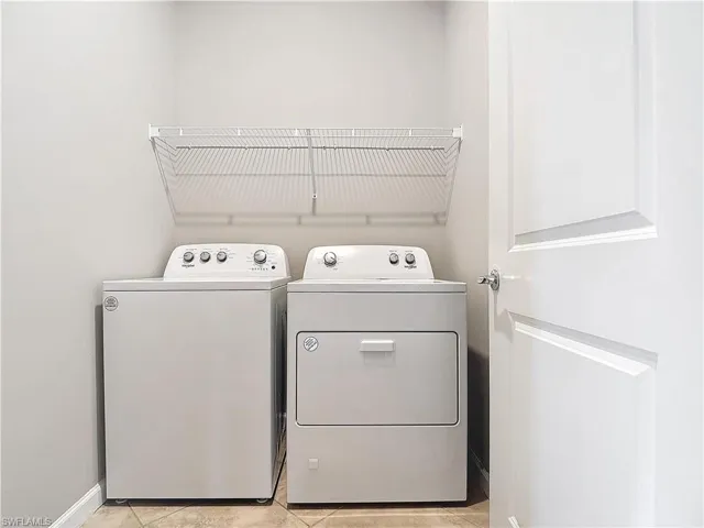 Laundry area featuring washer and dryer, laundry area, and baseboards