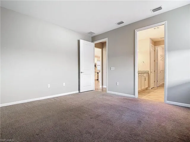 Unfurnished bedroom with visible vents, light carpet, and baseboards