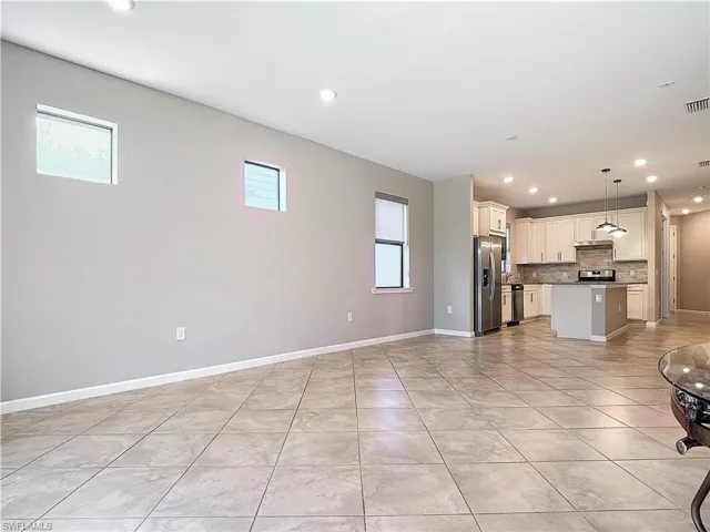Unfurnished living room with recessed lighting, baseboards, and a wealth of natural light