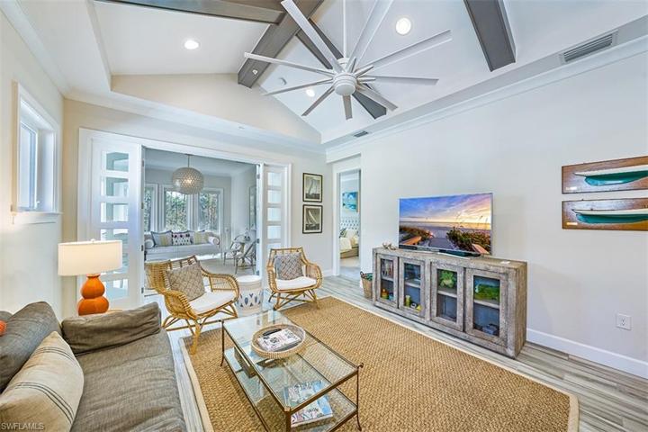 View from the kitchen of the great room with vaulted/beamed ceiling. The sunroom with French doors faces the nature preserve.