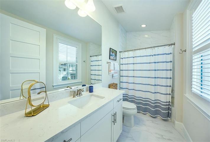 En Suite Bathroom features quartz countertops and plantation shutters.
