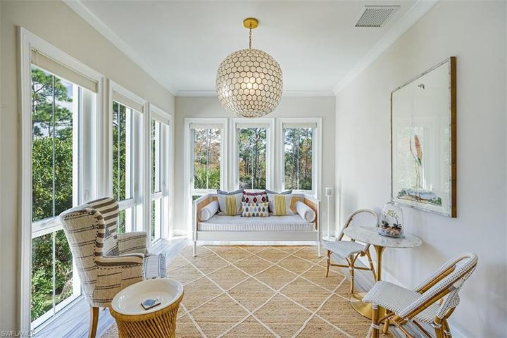 Enjoy beautiful sunrises over the nature preserve from the sun room with French doors and Serena & Lily chandelier.