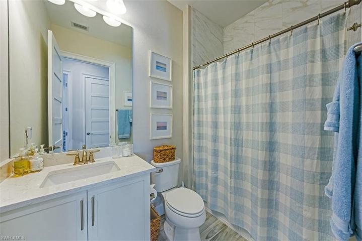 The third full bathroom features upgraded tile and quartz countertops.