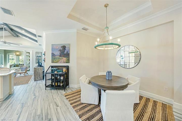 The dining area, which features a designer chandelier and tray ceiling, is open to the great room.