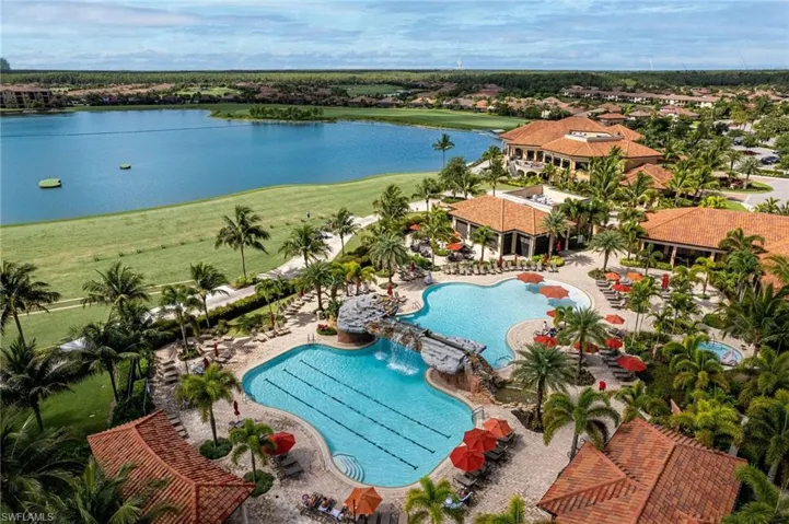Expansive aquatic recreation area featuring multiple swimming pools, a rock waterfall, and surrounding lounge seating