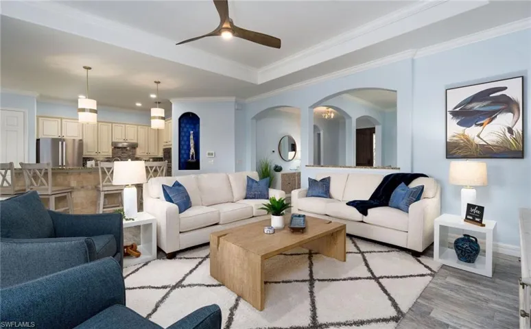 Open-concept living area with tray ceiling and recessed lighting