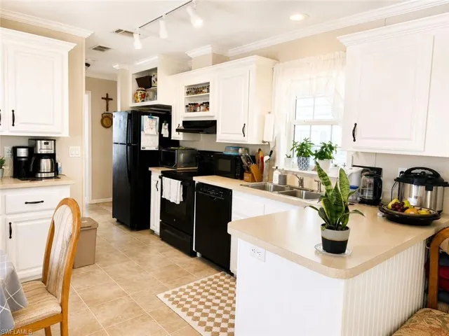 Bright kitchen featuring white cabinetry and light countertops