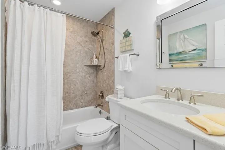Full bath featuring toilet, shower / tub combo with curtain, and vanity