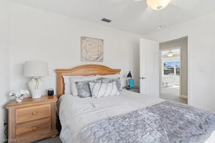 Carpeted bedroom with ceiling fan and visible vents
