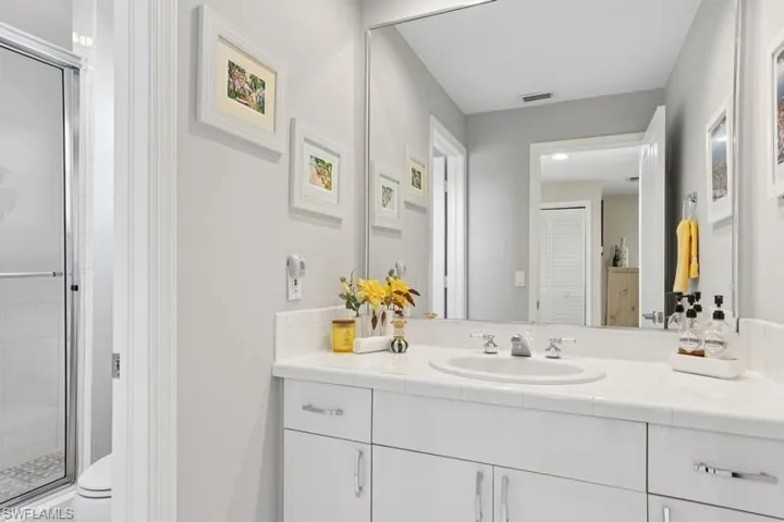 Full bathroom with a shower stall, vanity, and toilet