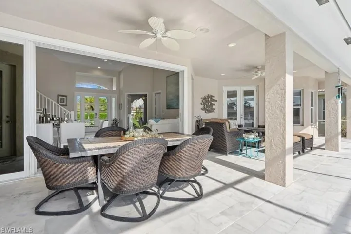 View of patio with french doors, ceiling fan, and outdoor dining space
